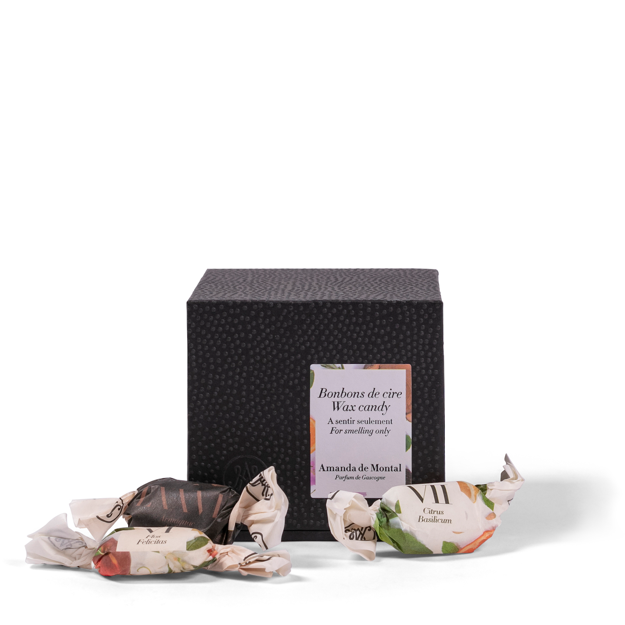 A small, elegant black box containing a variety of perfumed wax candies. Each scented wax candy is crafted from natural, plant-based waxes, precisely blended to release delightful aromas. 