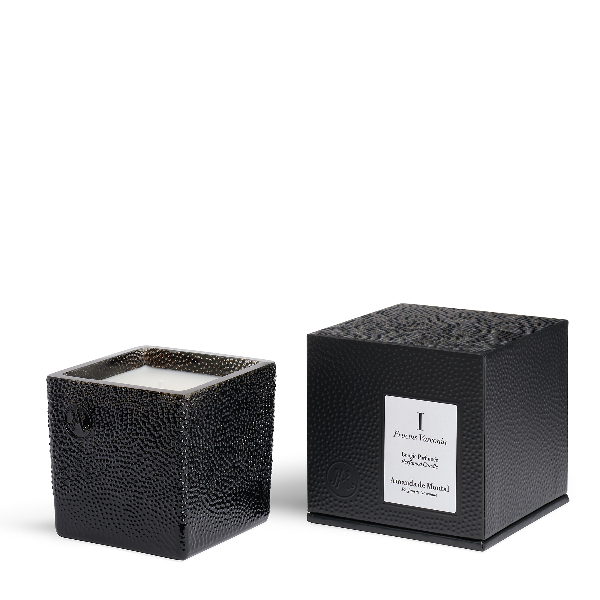 The artisanal black glass candle vessel contains thousands of bubbles, revealing a twinkling flame. Sweet fig mingles with the scent of warm grass and nourishing plums.