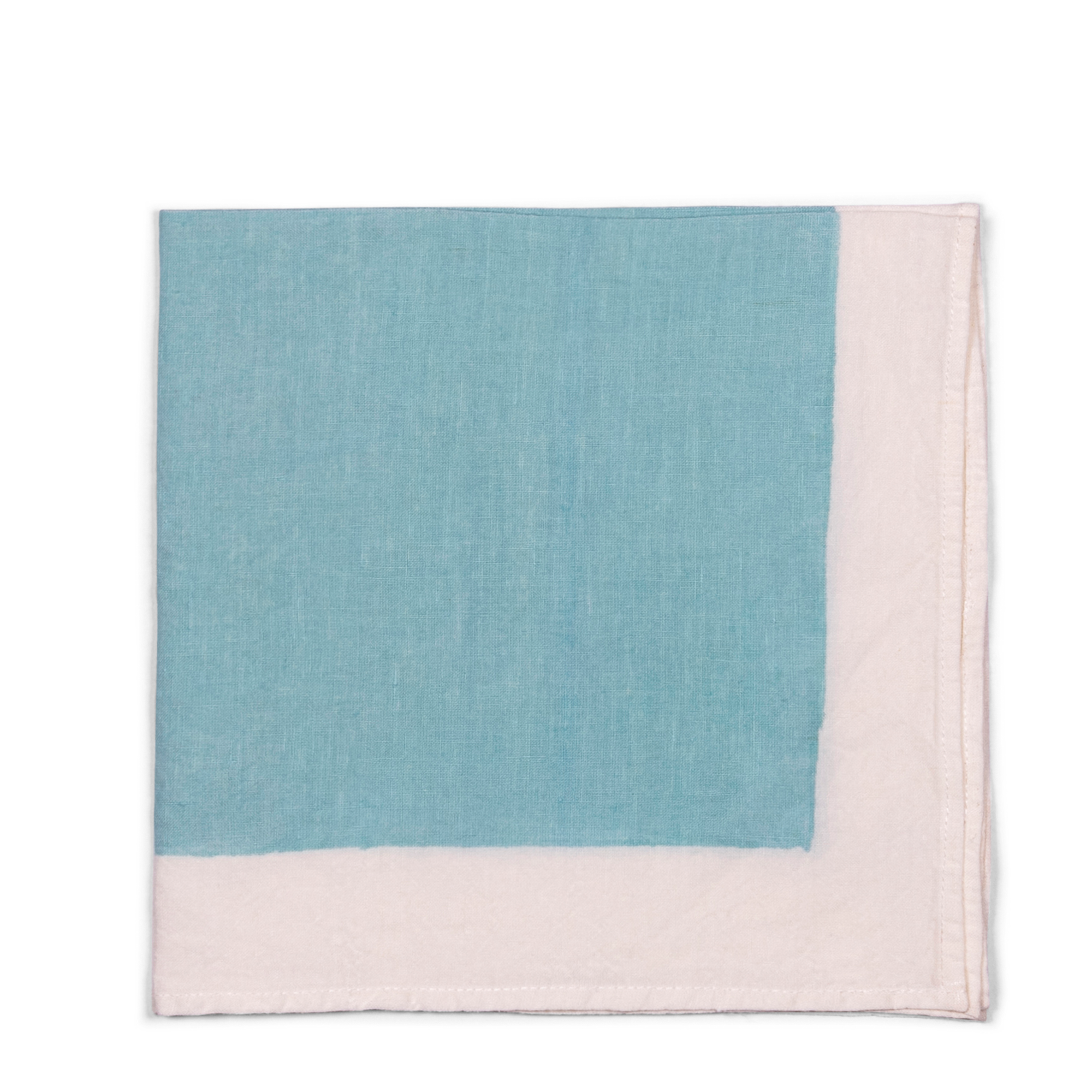 A stylish light blue linen napkin with white borders, handmade using pear wood. Can be used for breakfast, formal dining, or garden tablescape.