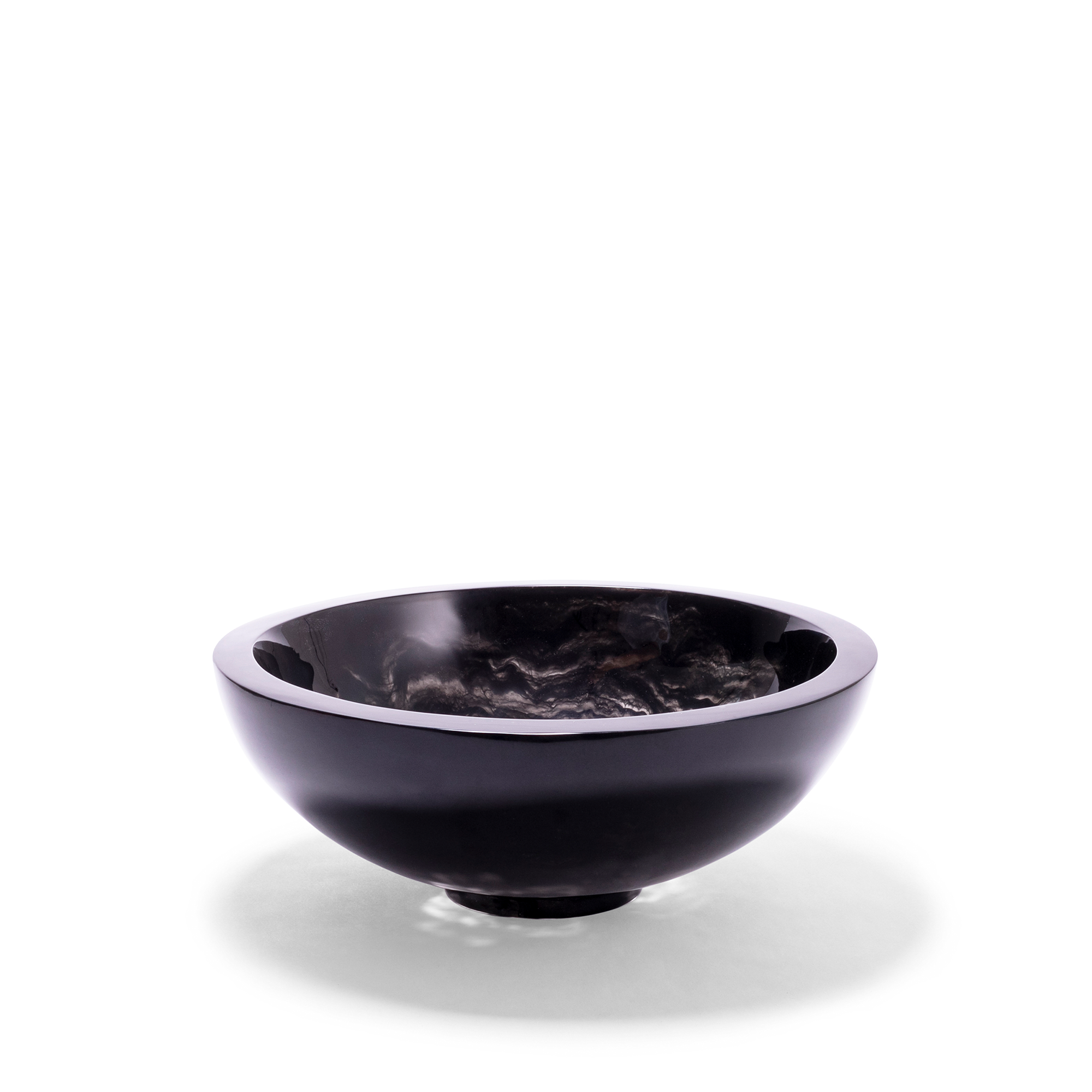 A sleek, smaller black bowl with a smooth, polished exterior and a deep, reflective finish that contrasts with the textured, swirling patterns inside the bowl. The bowl has a rounded design with a slightly elevated base, creating a dramatic centerpiece for any contemporary decor.